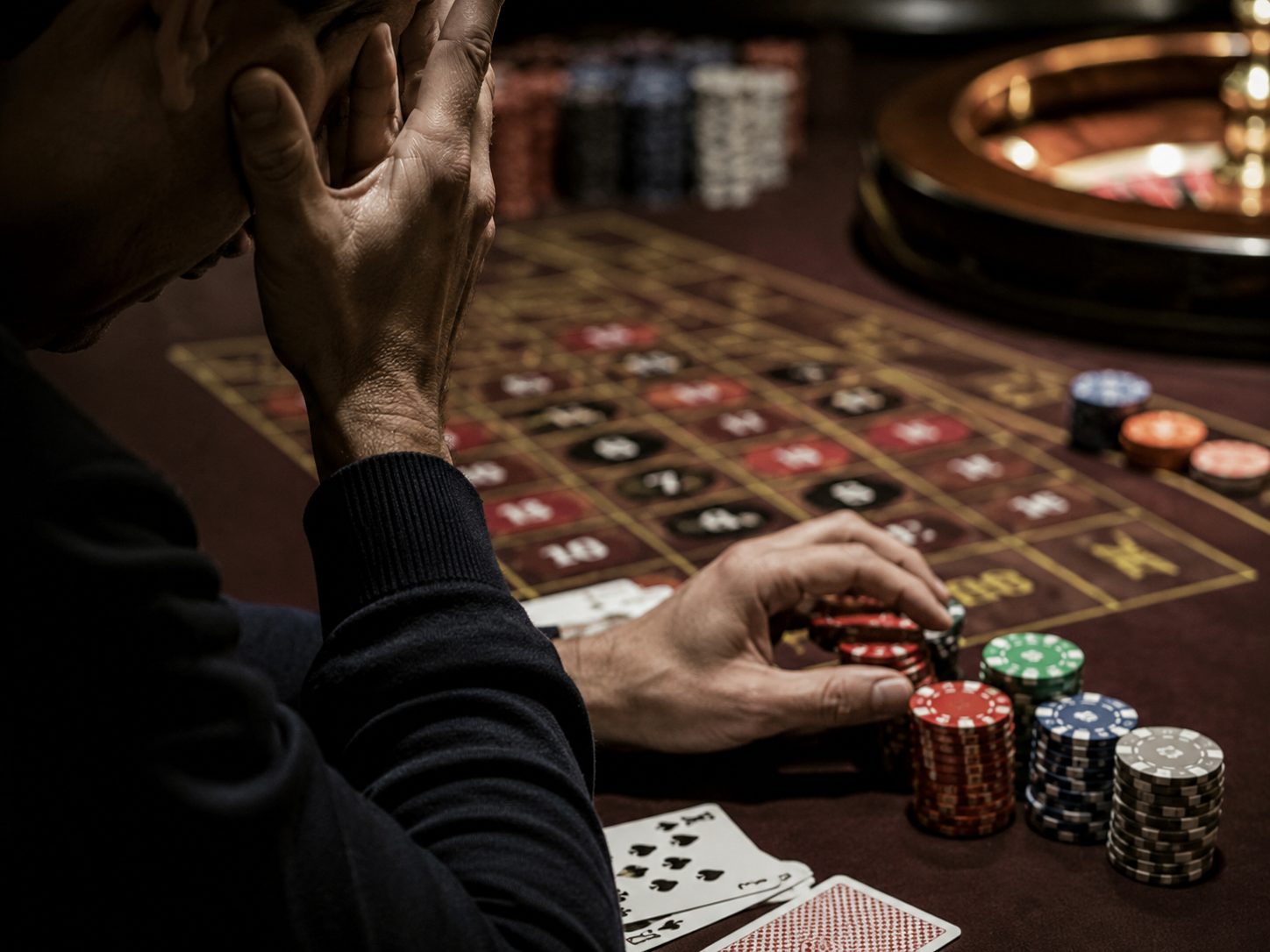 Close-up of hands, chips and cards at a casino roulette table