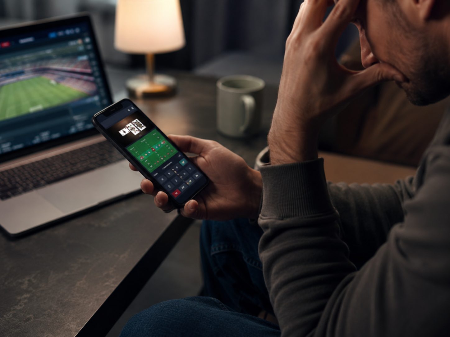Person using a phone to gamble on sport, showing how online gambling is always within reach